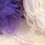 white and purple bath puffs